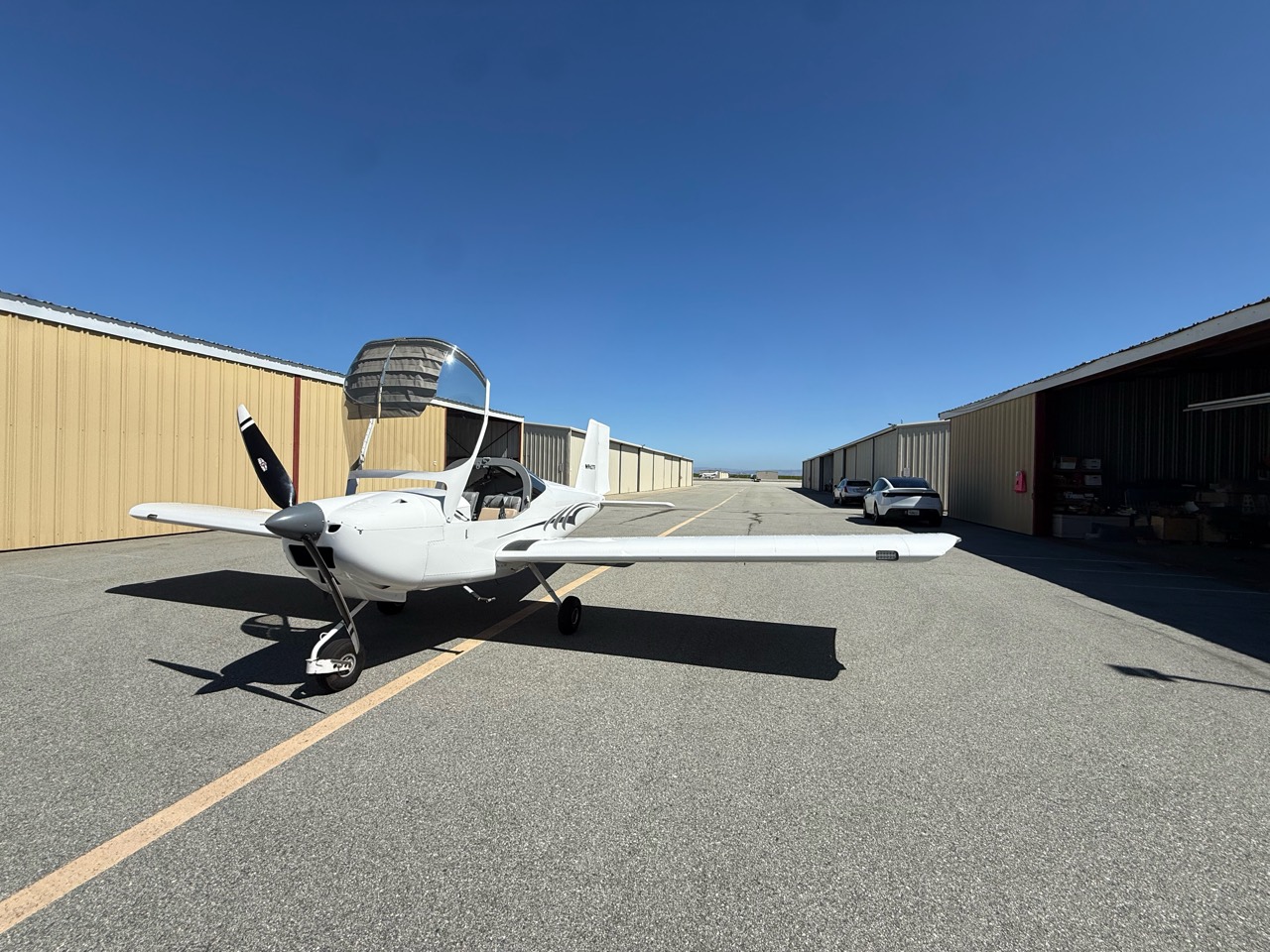 N962TF parked between hangars with its canopy open