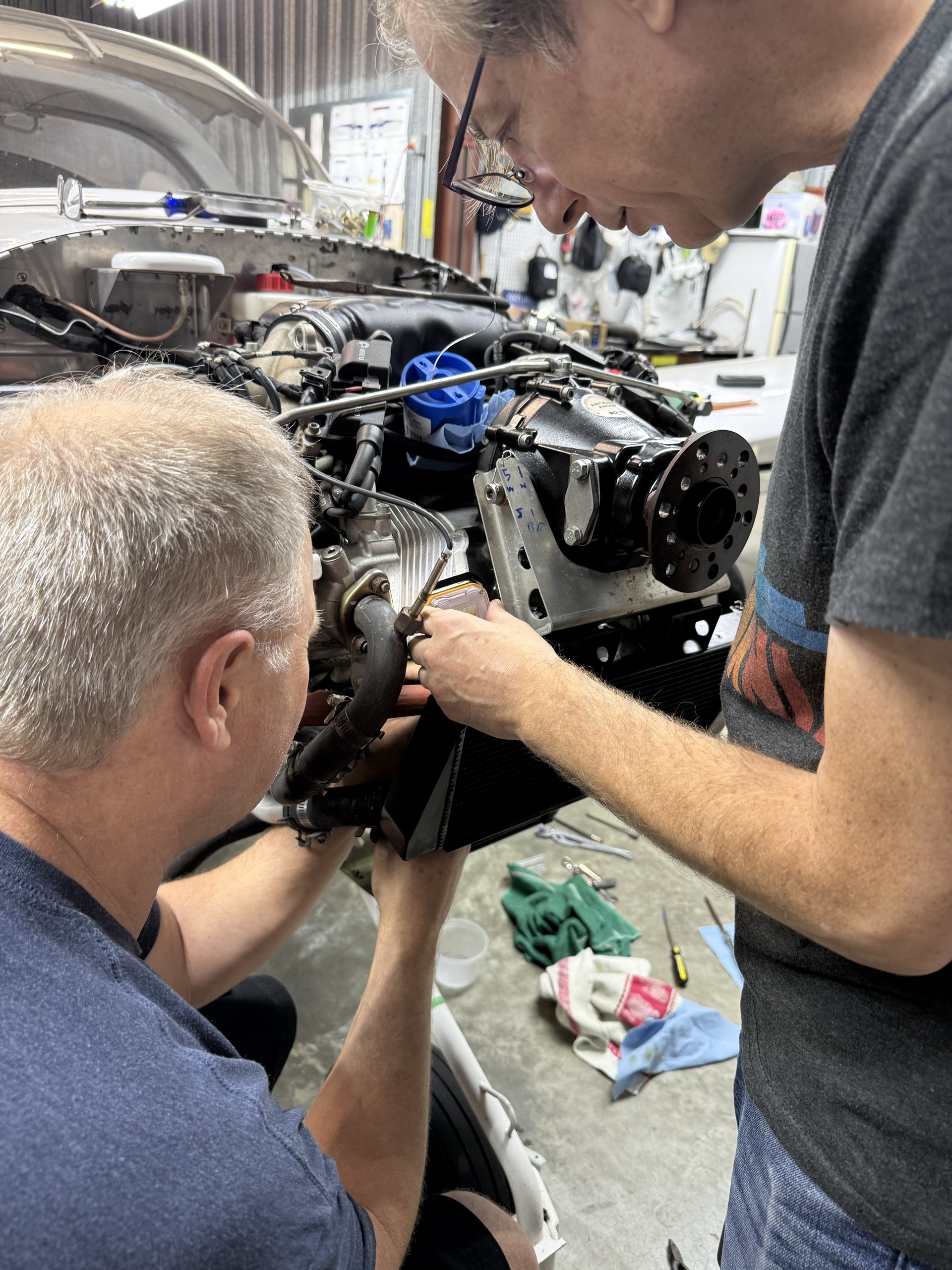 Two people working together on the aircraft engine in the hangar