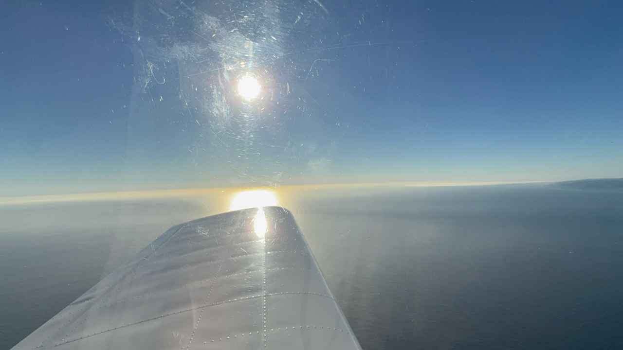 Sunlight over the ocean and airplane wing